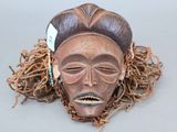un gros plan d'un masque en bois orné de dreadlocks