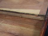 an old wooden box with a lid that is open on a black background
