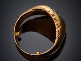 a close up of a gold ring on a black surface