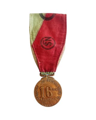 une ancienne médaille avec un ruban rouge sur fond blanc