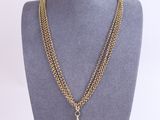 a gold chain necklace with a blue stone pendant on it