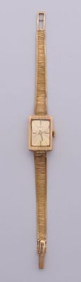 a gold wrist watch with a square face on a white surface