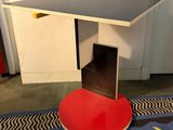 une table rouge avec un plateau noir posée sur un tapis bleu