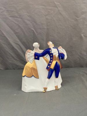 une figurine représentant deux personnes vêtues de bleu et de blanc