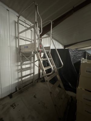 une photo d'une pièce avec une échelle et de nombreuses boîtes