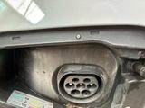 a close up of a car ' s fuel tank with a plug in it