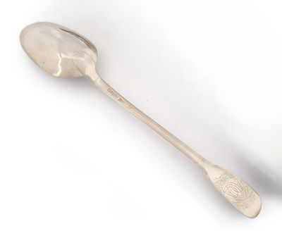 une cuillère en argent avec un manche de cuillère sur une surface blanche