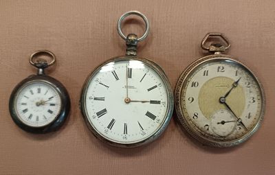 three different types of pocket watches displayed on the wall