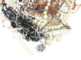 a pile of assorted beads and jewelry on a white surface