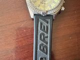 la montre est posée sur une table en bois et est dotée d'un bracelet noir