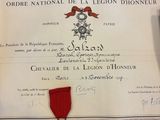 un certificat avec un ruban rouge sur une table