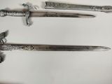 three different types of swords are displayed on a white surface