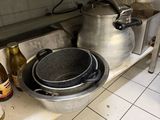several pots and pans sit on a shelf in a kitchen