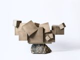 une sculpture réalisée à partir de blocs de carton posés sur un rocher