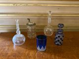 quatre bouteilles en verre différentes posées les unes à côté des autres sur une table