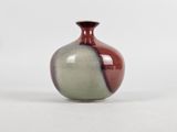 a small vase that is sitting on a white surface