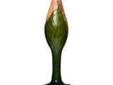 un vase vert orné d'une fleur, posé sur une surface blanche