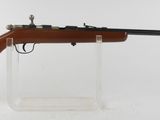 un fusil avec un canon en bois sur un support transparent