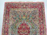 an antique persian rug with a floral design on a blue ground