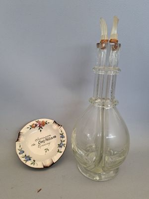 un petit vase en verre et une petite assiette posés sur une table