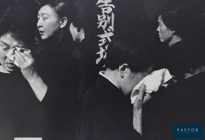 black and white photograph of a group of people eating food