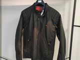 une veste en cuir noir accrochée à un porte-manteau dans une pièce