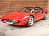 a red sports car parked in front of a brick wall