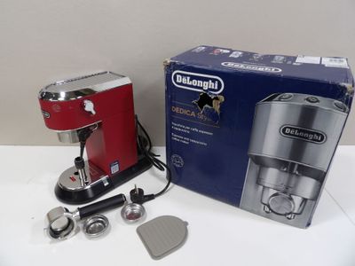 a red coffee maker sitting on a table next to a box of coffee