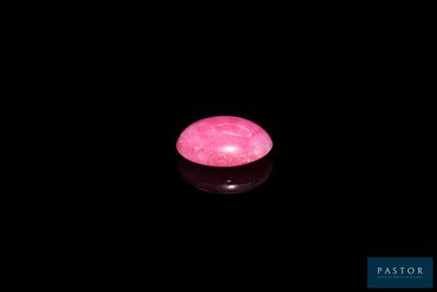 une bougie rose allumée dans l'obscurité