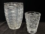 two glass vases sitting next to each other on a table