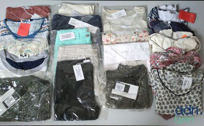 many different types of clothing in bags on a table