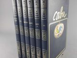 the four books are lined up in a row on a gray surface