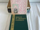 two books on a bed with a white sheet in the background