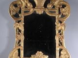 an image of a gold mirror on a stand with a black background