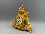 une horloge en or surmontée d'une statue