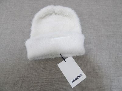 bonnet blanc en tricot avec étiquette, sur tissu gris avec étiquette