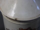 a white vase with a brown design on it
