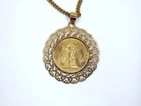 a close up of a necklace with a coin on a chain