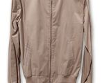 une veste beige suspendue à un cintre sur un mur blanc