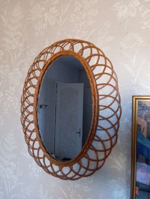 un miroir accroché au mur, à côté d'une photo de chat