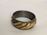 an image of a gold and silver ring on a white surface
