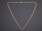 un collier en or avec une chaîne sur un fond sombre