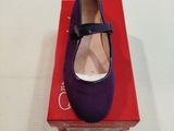 des chaussures violettes posées sur une boîte rouge, elle-même posée sur une surface blanche