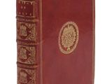 un vieux livre rouge orné d'un médaillon doré sur la couverture