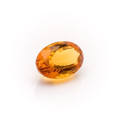 a yellow sapphire stone on a white background