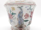 un vase orné d'un poisson, posé sur un fond blanc