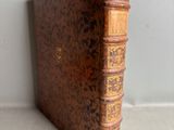 an old book sitting on top of a table next to a wall