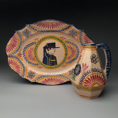 une assiette sur laquelle figure l'image d'un homme, à côté d'un vase