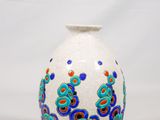 un vase blanc orné de fleurs bleues et rouges