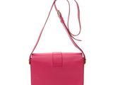 a pink purse with a long strap on a white background
